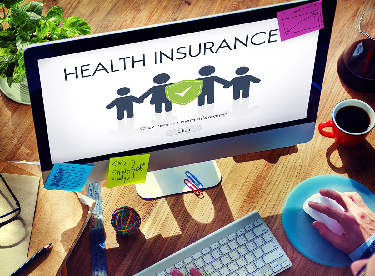 桌面电脑屏幕上显示一个家庭图标和“健康保险”字样