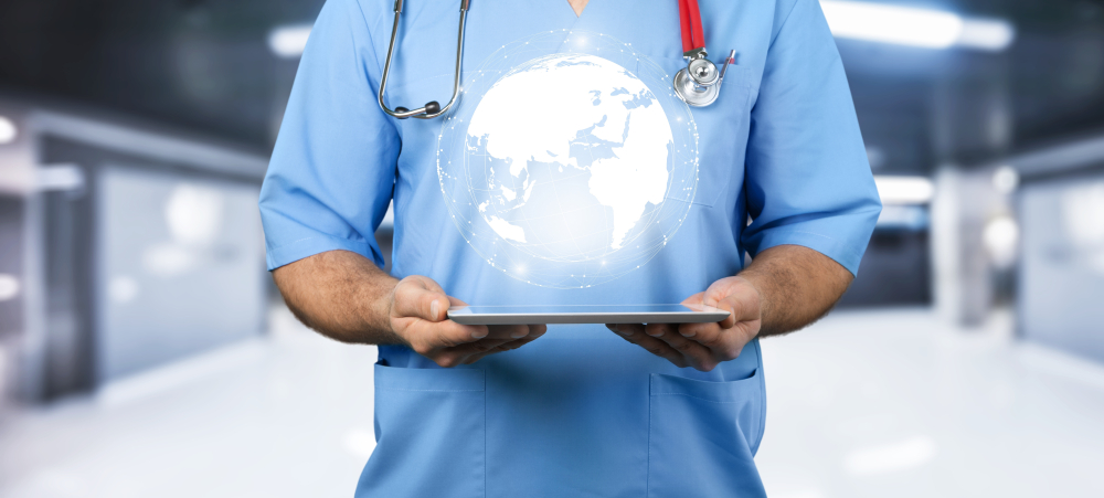 医疗专业人员拿着一个数字平板电脑，屏幕上方盘旋着一个全球图标